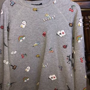 Gray crew neck with images and writing.